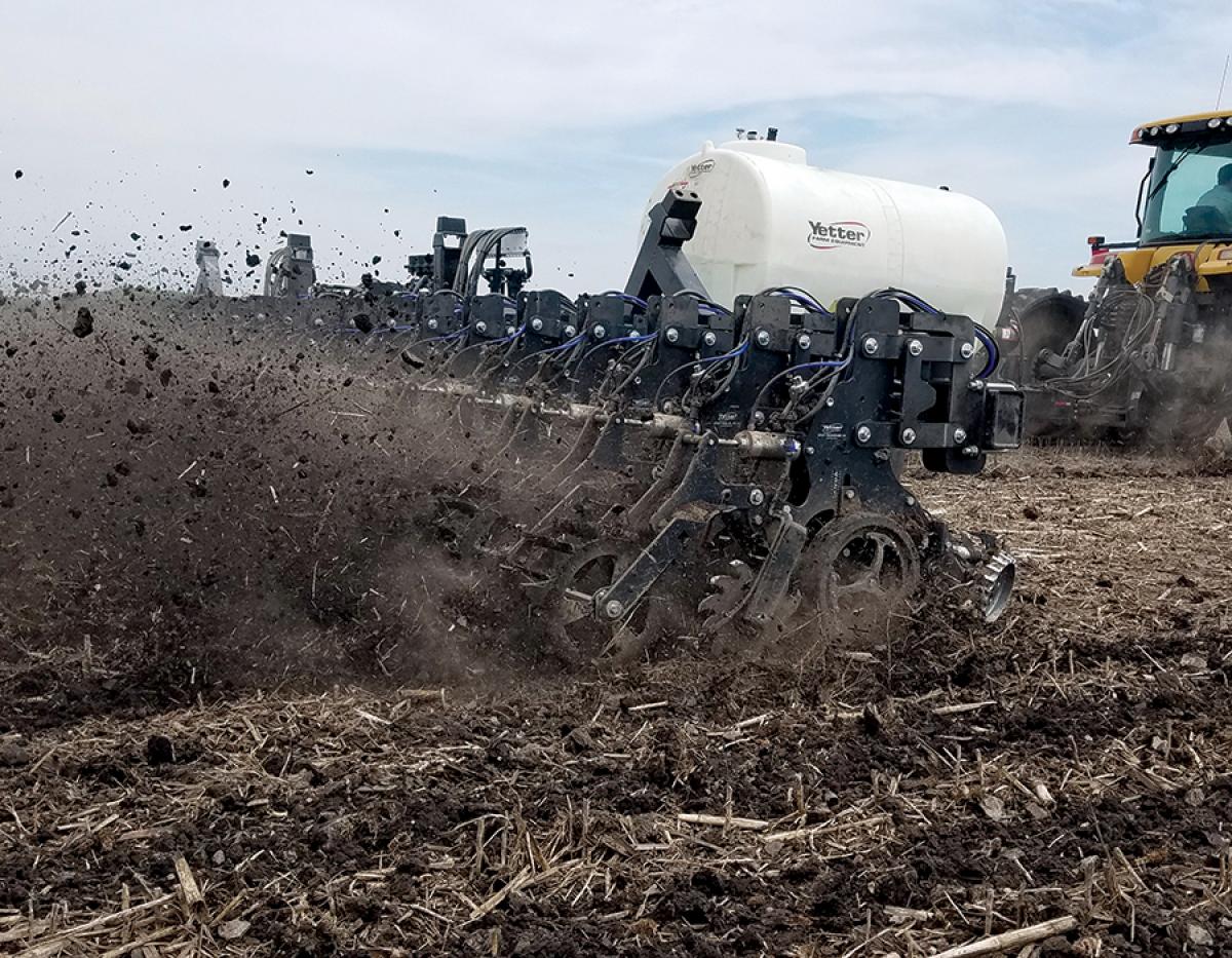Strip Freshener action shot tilling in field with fertilizer tank