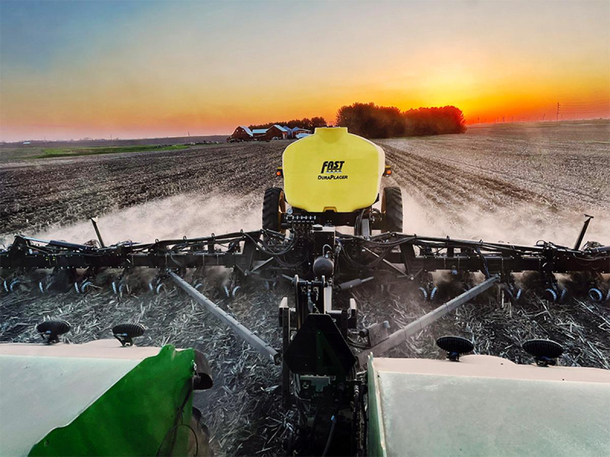 View from tractor of Strip Freshener CCs on Fast DuraPlacer toolbar running in the field at sunset